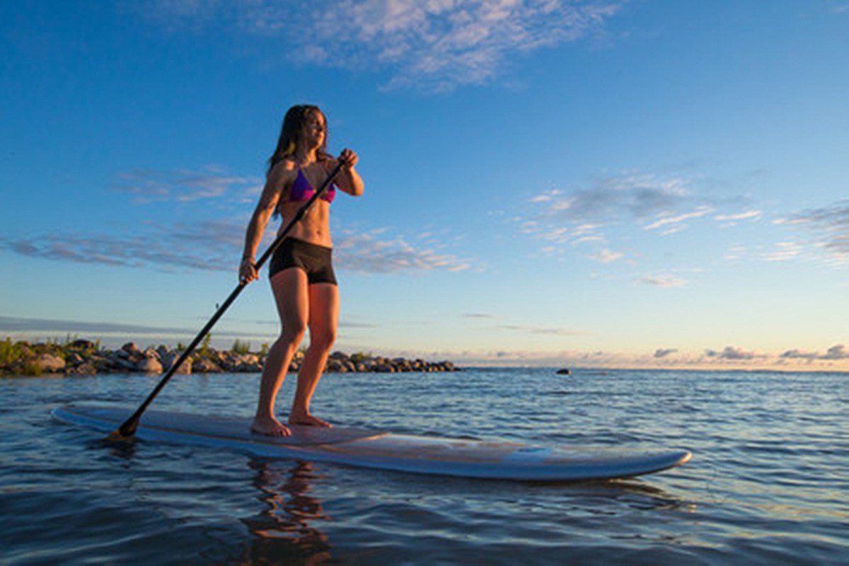 Woman paddle boarding in the evening
