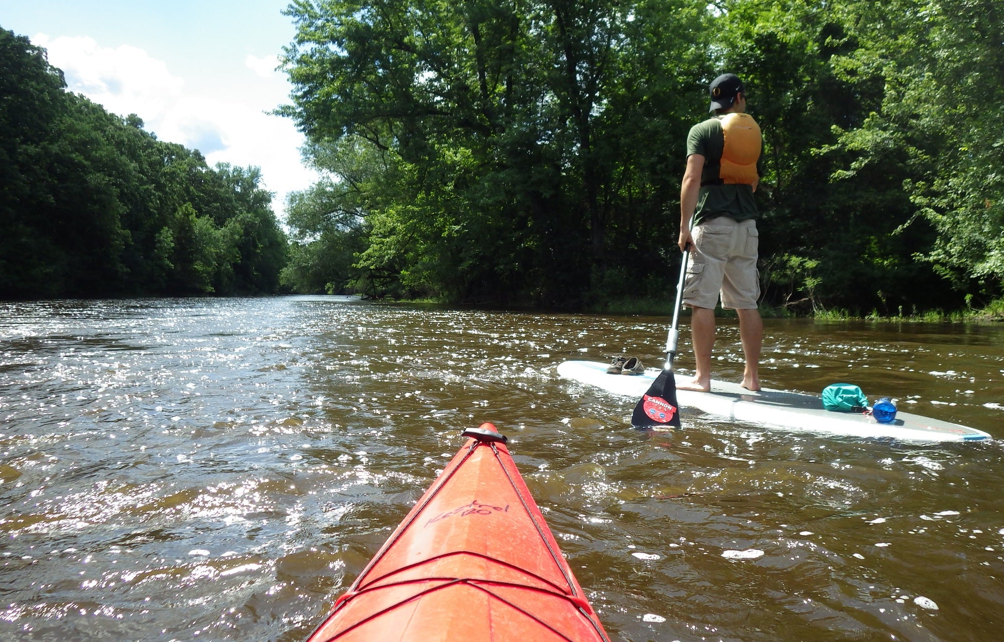 Kayaker and paddle board on river