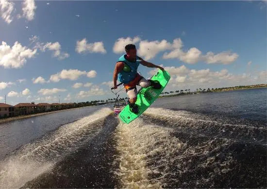Man on wakeboard jumping tow boat's wake