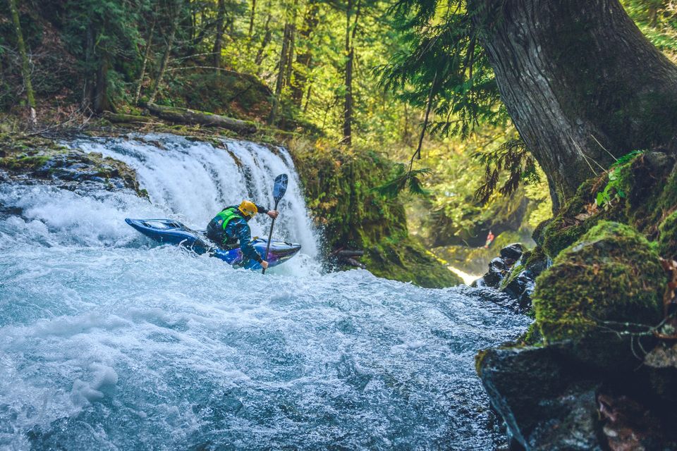 whitewater kayaker approaching a waterfall drop