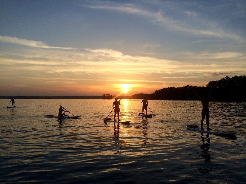 Group paddleboarding on Lake Lanier during sunse