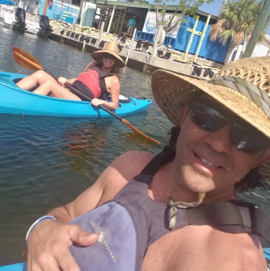 Tim taking a selfie of Ginger and himself floating on kayaks in the ocean