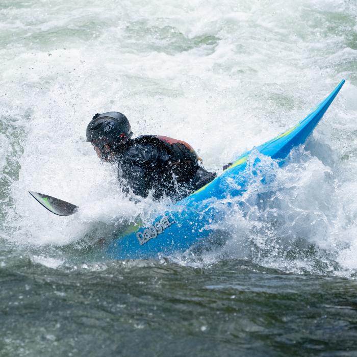 Kayaker performing a trick in a rapid