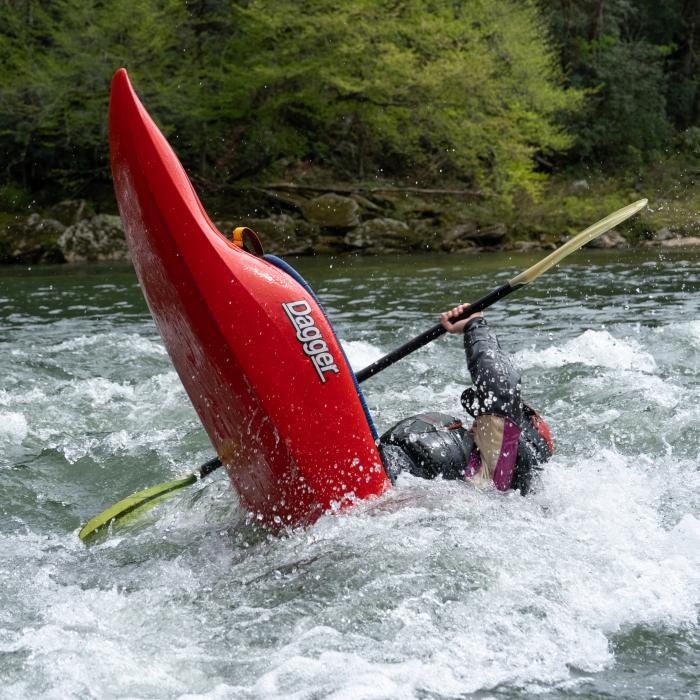 kayaker performing a stern squirt in a Dagger whitewater kayak