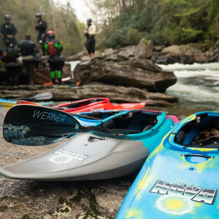 Several Dagger Supernova kayaks lined up on creek's bank